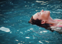 Mujer relajada en una piscina de agua completamente limpia gracias al uso de un clorador salino